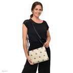 Slop Cannon Cherry Fuse Repeat Crossbody Bag — Cream / black trim — model-worn front view; bag only; styling clothing excluded; printed faux leather with black trim; digital model composite with exact supplier bag, strap and print pixels. Not a manufactured sample photograph.